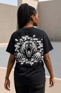 Frau von hinten trägt ein schwarzes T-Shirt mit großem Bärenrückenprint auf einem offenen Sportplatz.