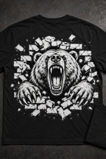 Schwarzes T-Shirt flach ausgelegt mit großem grizzly motiv auf dem Rücken und kleiner Brustansicht daneben, auf dunklem Industriehintergrund.