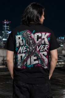 Rothaarige Frau von hinten trägt schwarzes Rock T-Shirt mit großem „Rock Never Dies“-Motiv vor einer Graffiti-Wand, concert outfit im Alternative-Look