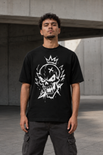 Mann trägt ein schwarzes T-Shirt mit weißem Totenkopf-Design als Lifestyle-Aufnahme vor modernem Betonhintergrund; punk rock shirt, rock shirt.