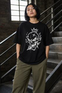 Person mit kurzem schwarzem Bob trägt ein schwarzes T-Shirt mit weißem Skull Design auf einer Treppe in einem Industrie-Interieur; alternative shirt, gothic tshirt.