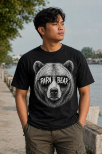 Mann trägt schwarzes Papa Bear T-Shirt an einer Uferpromenade, das Tiermotiv T-Shirt mit Sonnenbrille fällt frontal ins Auge