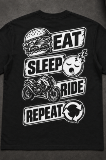 Schwarzes T-Shirt flach ausgelegt mit großem Eat Sleep Ride Rückendruck, neben einem Schraubenschlüssel auf dunkler Werkbank