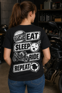 Frau von hinten trägt ein schwarzes Eat Sleep Ride T-Shirt in einer Motorradgarage neben einem großen Bike, lässiger geschenk biker Stil
