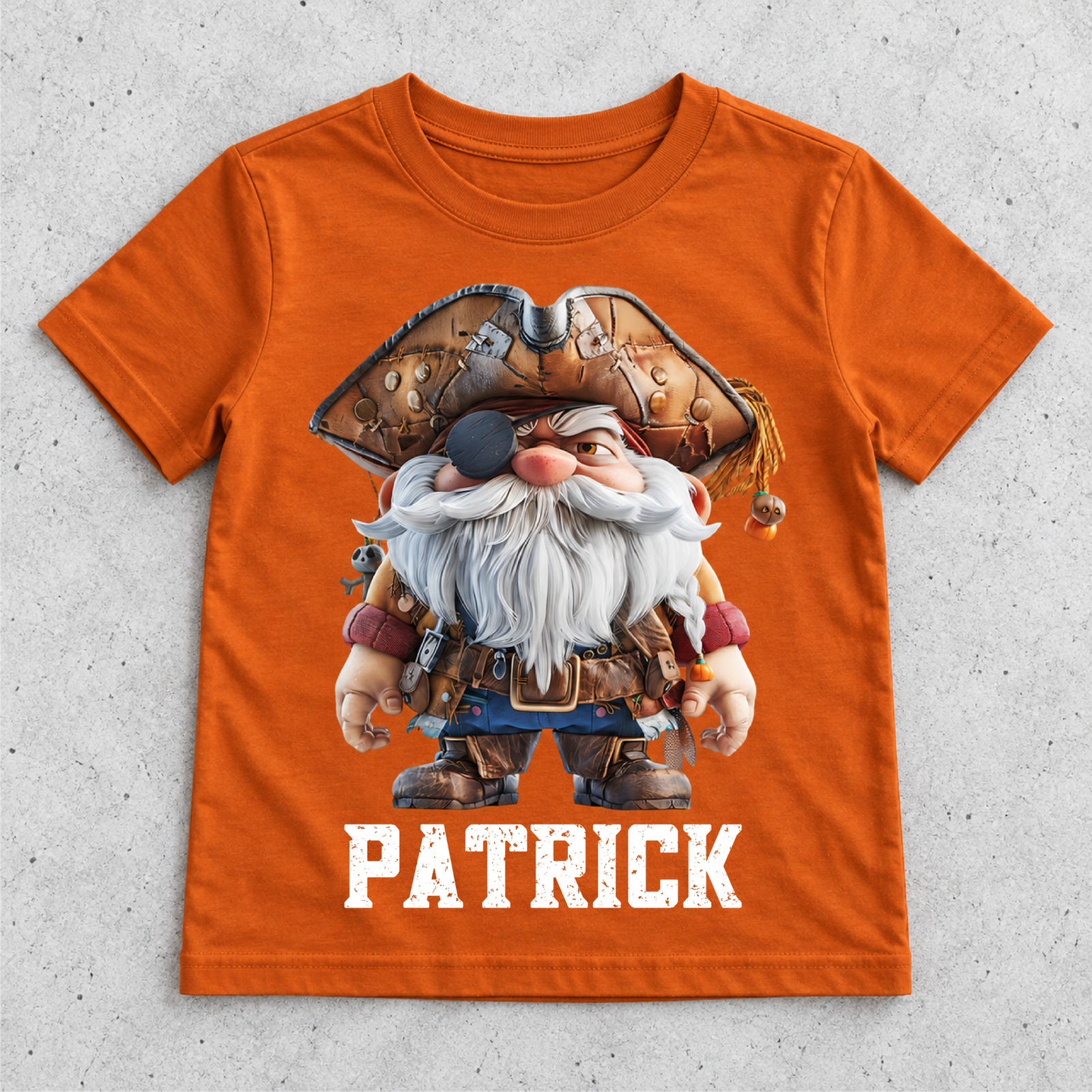 Orangefarbenes T-Shirt freigestellt auf hellem Hintergrund, mit Pirat-Gnom-Print und dem Namen Patrick unter dem Motiv.